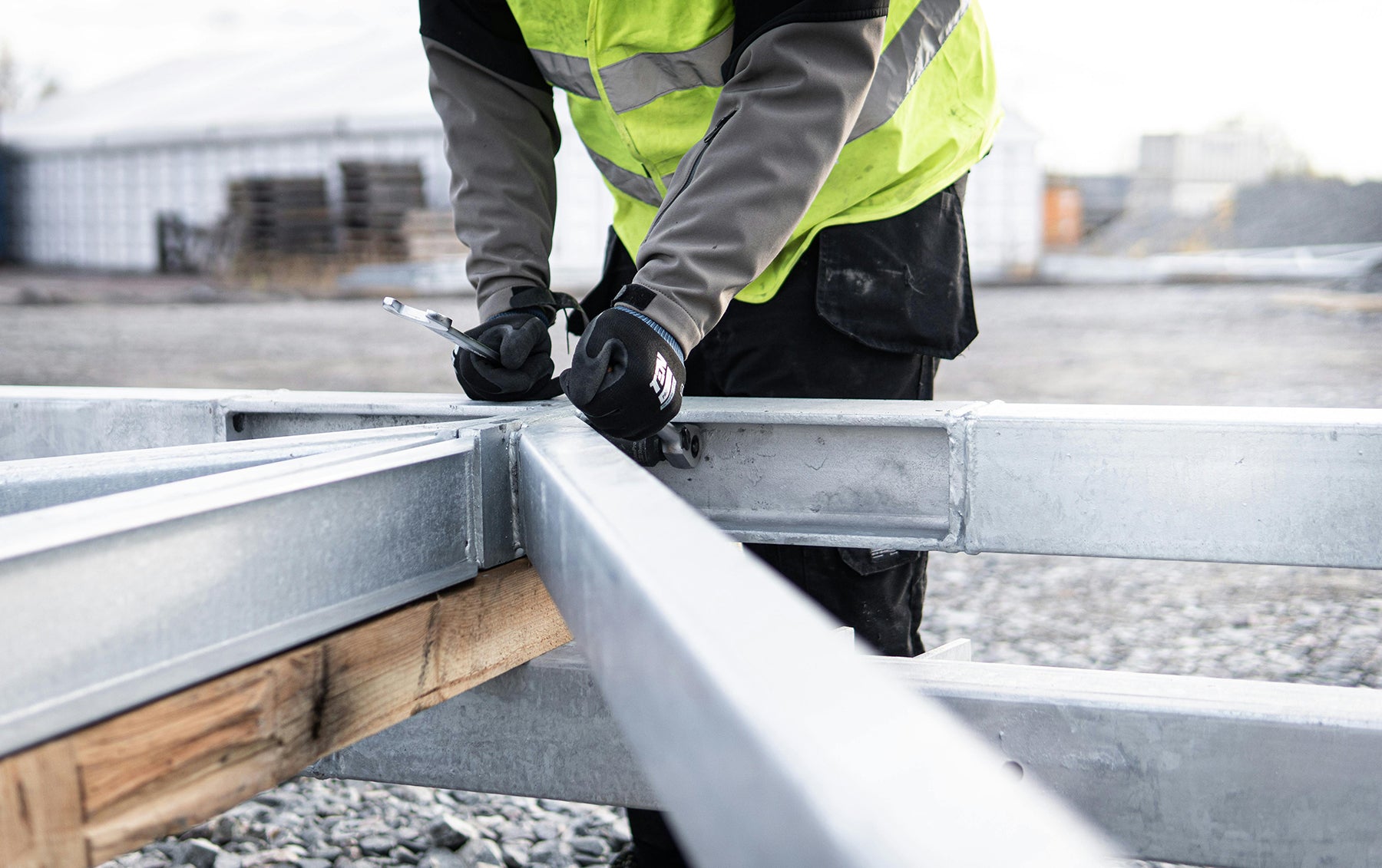 Person in high-visibility jacket working on metal framework