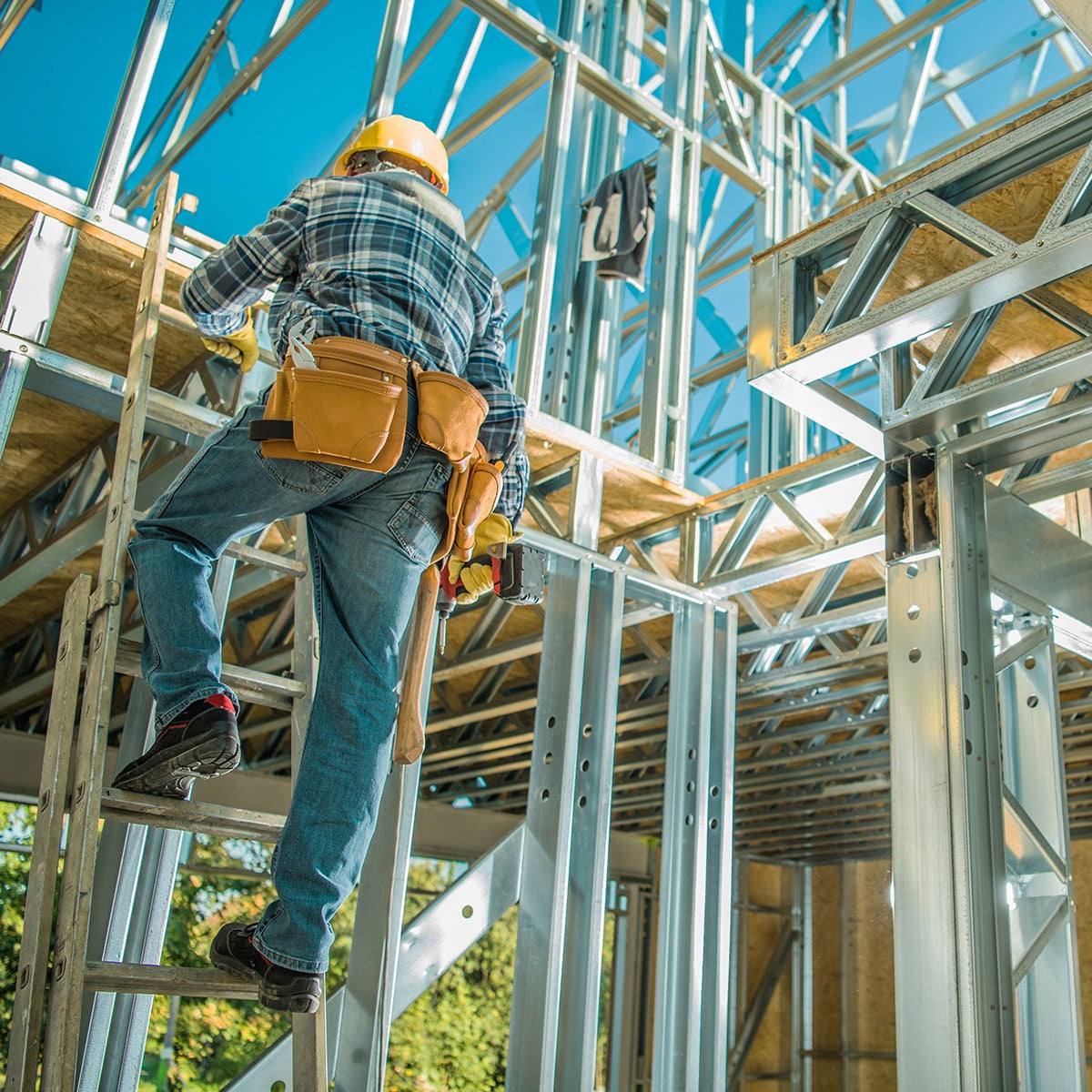 Person on a ladder working on a metal frame structure